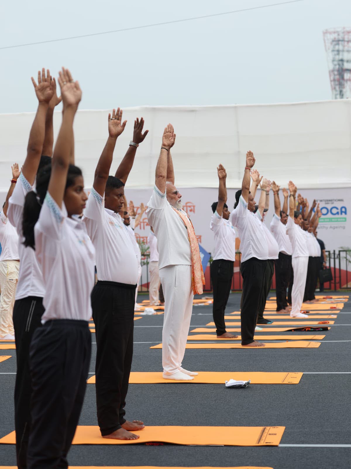 Arms raised in unison — the power of collective practice at IDY 2026.